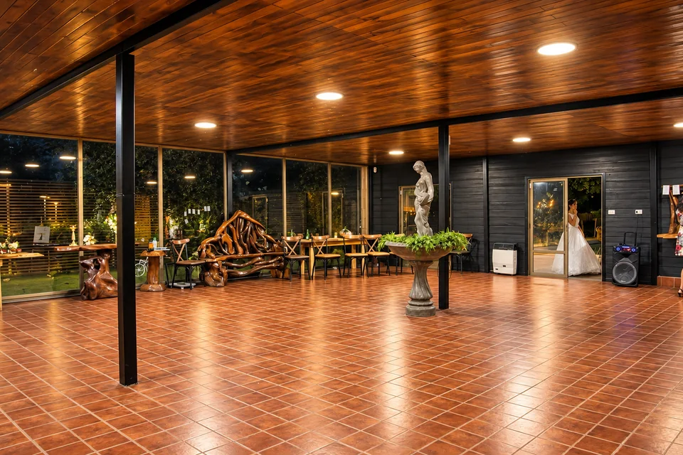 Zona de cóctel con techo de madera y ventanales hacia el jardín