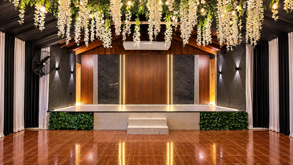 Escenario del salón con fondo de madera y flores suspendidas